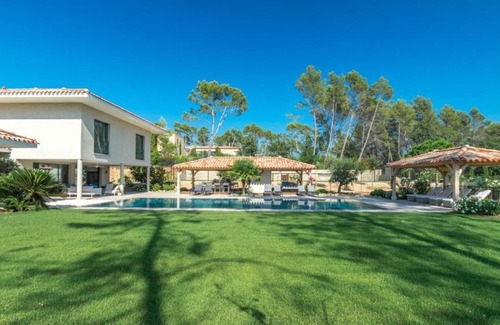 Magalas Apartamento | A large table with chairs and a garden furniture with sunbeds
