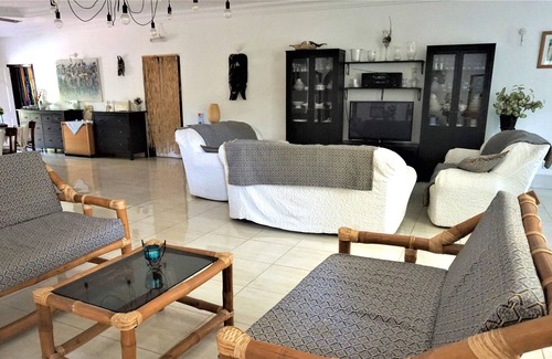 Serrekunda Cama Y Desayuno | Bonita habitación con cama doble junto a la piscina en un jardín tropical.