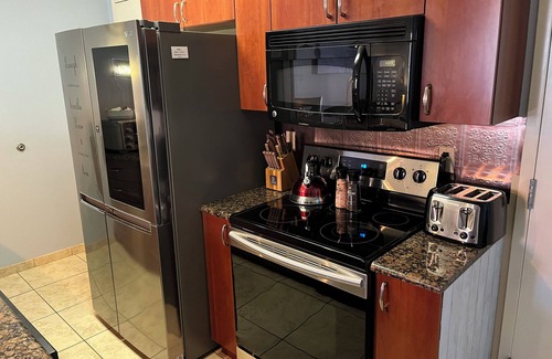 National Gardens Condominio | Cozy 1-bedroom condo with 75 inch TV, Granite & stainless kitchen, Pool, W&Dryer