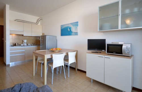 Lignano Sabbiadoro Apartamento | Hermoso apartamento con A/C, piscina, TV, terraza, mascotas permitida y aparcamiento