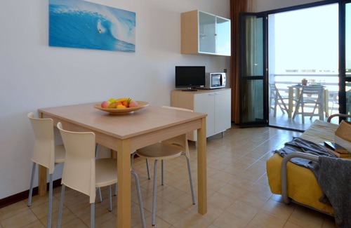 Lignano Sabbiadoro Apartamento | Hermoso apartamento con A/C, piscina, TV, terraza, mascotas permitida y aparcamiento