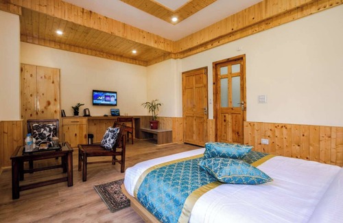 Manali Chalet De Esquí | Bedroom in a stone and wood chalet admist apple garden