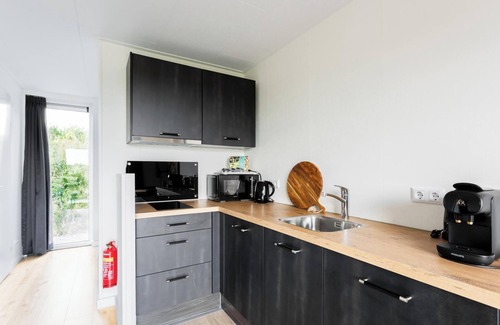 Gasselte Casa | Charming tiny house with a deck by the water. Relax, enjoy nature near ’t Nije Hemelriek and unwind – from sipping cappuccino in the sun to stargazing by the firepit.