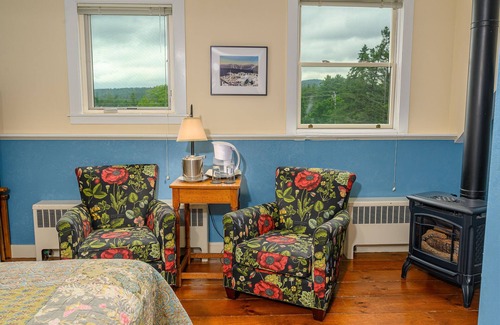 Stowe Cama Y Desayuno | Comfortable room with queen bed, a stunning view of Mount Mansfield, sitting area and a parlor stove with full service breakfast included