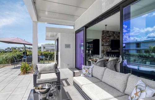 Zeewolde Casa | Detached 6-person villa by the water with a cosy living room featuring a piano and fireplace, modern kitchen with cooking island, and a sunny garden with lounge set.
