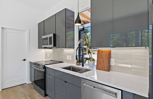 Young Harris Apartamento | Enjoy treetop views in a 2BR/1BA tiny home nestled in the North Georgia mountains. Whip up meals in the chef’s kitchen, cozy up by the wood-burning stove, unplug in the spa-style shower, relax on your private deck, and cool off in the community pool.