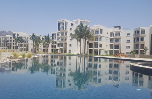 As Sifah Apartamento | Idílica residencia junto al mar. Exuberantes vistas al golf y al mar. Magníficas comodidades en el sitio.