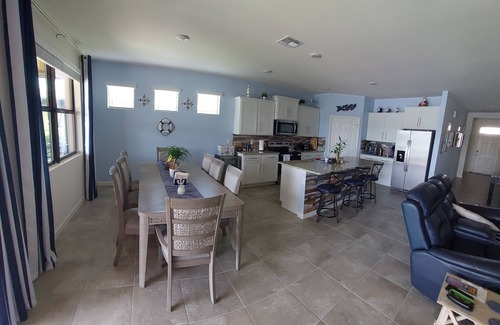 Port Malabar Casa | Lake view home with a screened outdoor entertainment area.
