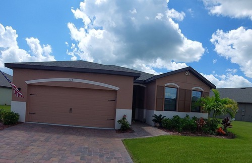 Port Malabar Casa | Lake view home with a screened outdoor entertainment area.