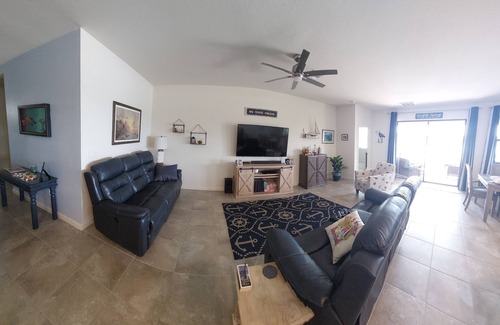 Port Malabar Casa | Lake view home with a screened outdoor entertainment area.