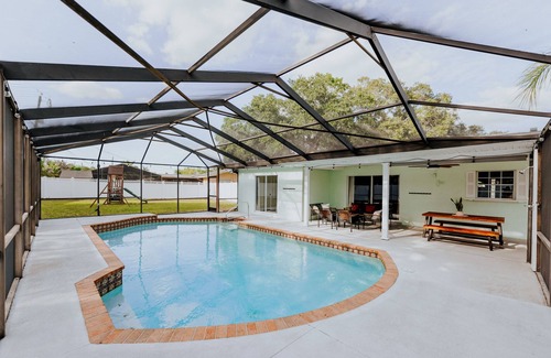 Palma Sola Casa | LUXE beach getaway 5mins from water. 3xKING BR, large heated pool + new playland