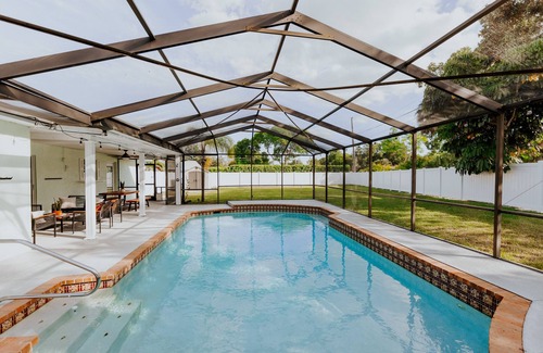 Palma Sola Casa | LUXE beach getaway 5mins from water. 3xKING BR, large heated pool + new playland