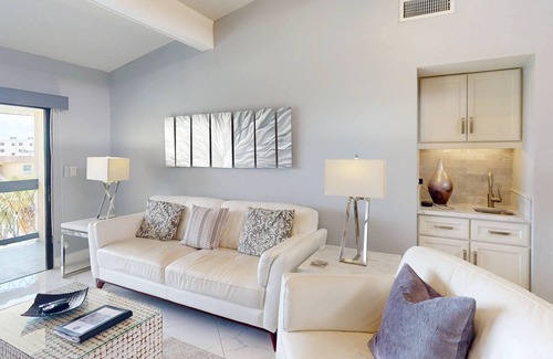 Capri Isle Condominio | Luxurious Coastal Condo with Waterway Views, Pool, Balcony, and Steps to Treasure Island Beach.