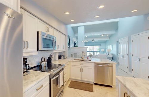 Capri Isle Condominio | Luxurious Coastal Condo with Waterway Views, Pool, Balcony, and Steps to Treasure Island Beach.