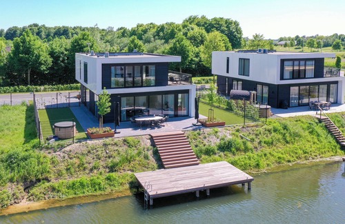 Biddinghuizen Casa | Luxury 8-person villa on the water with hot tub, private jetty, spacious terrace and 4 bedrooms. Located at Villa Resort Harderwold, near Harderwijk and the Veluwemeer!