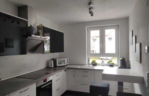 Baunatal Casa | Modern semi-detached house with covered terrace and fenced garden.