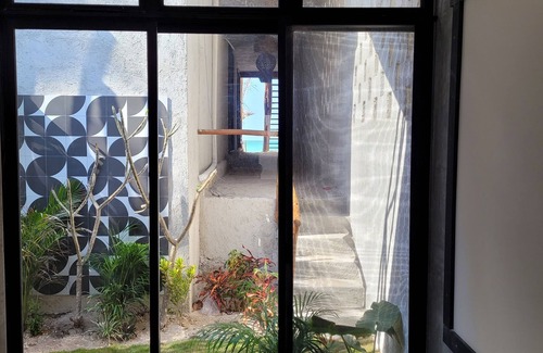 Chuburná Puerto Cabaña | Pasilla suite. Ocean view glass doors to the turquoise water, 13foot Tv screen