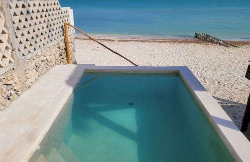 Chuburná Puerto Cabaña | Pasilla suite. Ocean view glass doors to the turquoise water, 13foot Tv screen