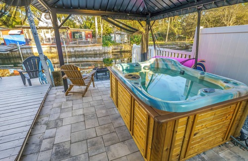 Weeki Wachee Gardens Casa | River home with huge arcade, hot tub kayaks, mini golf and floating pad, 80in TV
