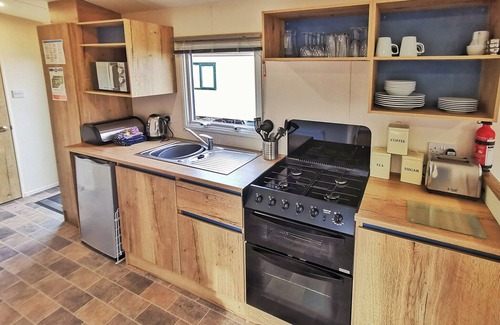 Llanllwchaiarn Casa | Spacious and well presented, 12-ft wide caravan with one double and one twin bedroom.