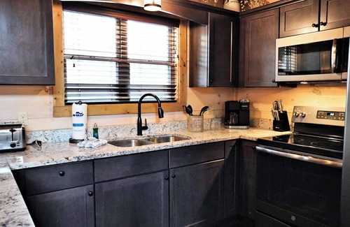 Pigeon Forge Complejo | Suite Retreat is a grand four-bedroom cabin located in Bear Cove Falls.