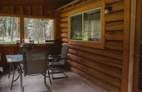 Seeley Lake Cabina | The Saddle Shed at Tamaracks Resort is a log cabin with furnished screen porch.