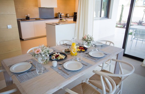 Vila Nova De Cacela Apartamento | Unwind on the shaded terrace overlooking the lush gardens and pool.