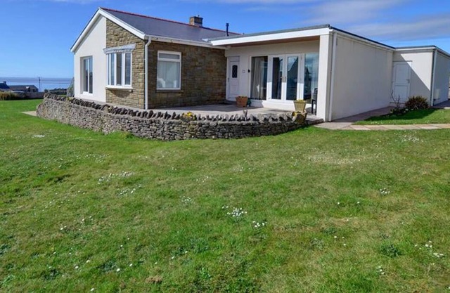 Una fantástica ubicación costera con vistas al mar desde este bungalow grande en Southerndown en Glamorga