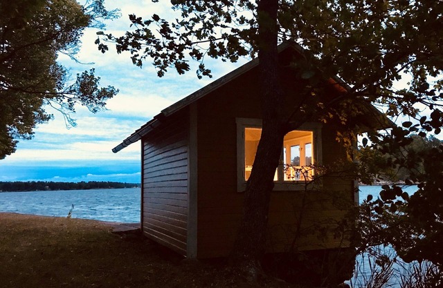 Cabaña con soleada terraza de madera junto al agua