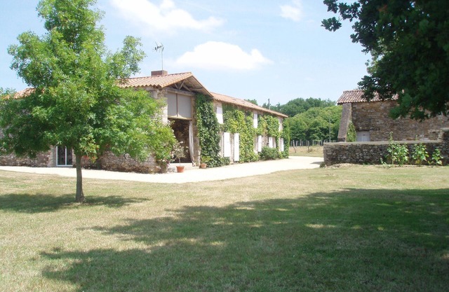 Antigua casa de labranza reformada en un entorno de prados y bosques.