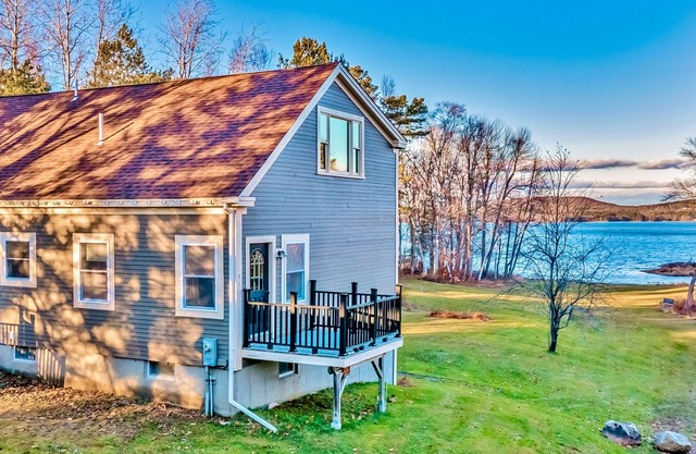 Ornate lake view home with wraparound deck, dock access & W/D