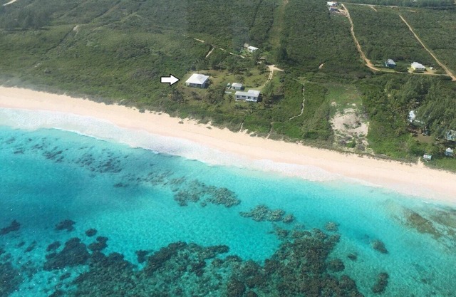 Casa privada y aislada frente a la playa en la playa desierta de arena rosa