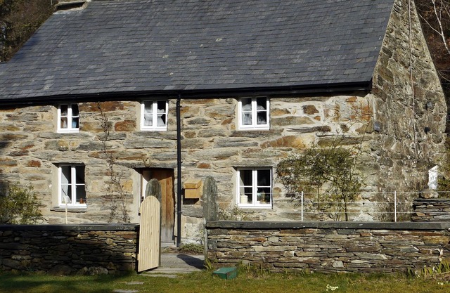 Romántica cabaña de piedra catalogada en el siglo XVII en el borde del lago en antiguos bosques de roble