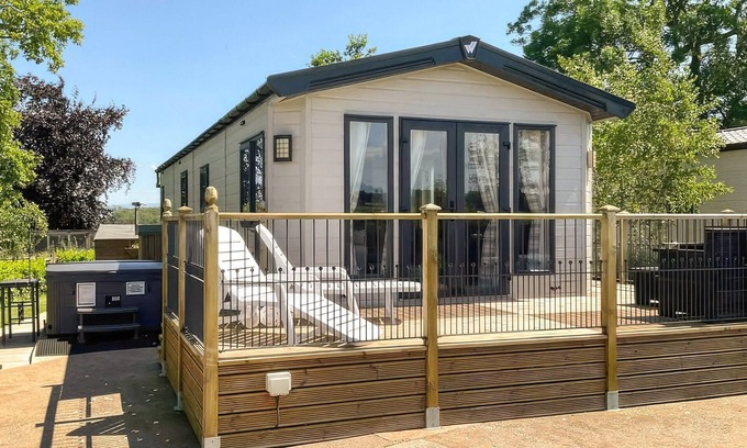 Penrith Cabaña | Detached luxury lodge with open plan living space, sleeps four, decked area and hot tub.