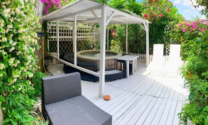 San Felice Circeo Apartamento | Circeii, apartamento con dormitorio, salón y exterior con bañera.