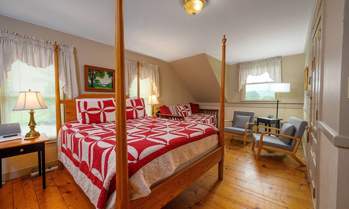 Stowe Cama Y Desayuno | Comfortable room with queen bed and daybed with windows on 3 sides, a stunning view of Mount Mansfield and a parlor stove with full service breakfast included