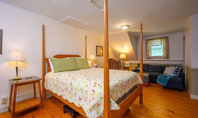 Stowe Cama Y Desayuno | Comfortable room with queen bed and twin trundle, a stunning view of Mount Mansfield, sitting area with couch and a parlor stove with full service breakfast included
