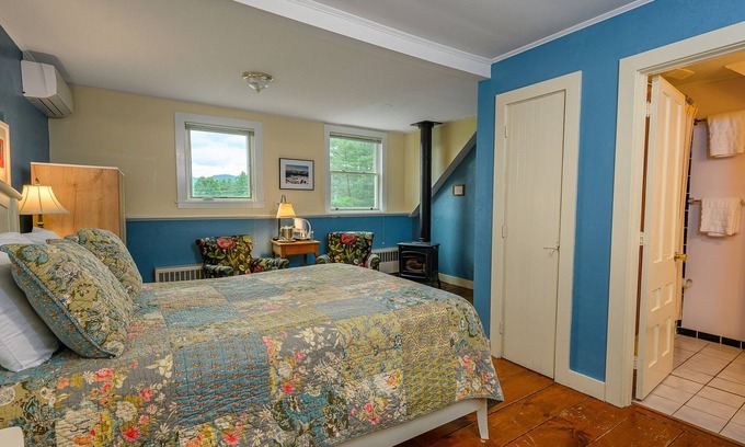 Stowe Cama Y Desayuno | Comfortable room with queen bed, a stunning view of Mount Mansfield, sitting area and a parlor stove with full service breakfast included