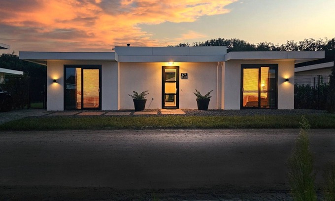 Zeewolde Cabina | Detached 6-person villa with paddleboards, waterfront garden with private swim deck, sunshade, BBQ, and luxurious open kitchen. Located at Villa Resort Harderwold in Zeewolde. Pet-friendly!