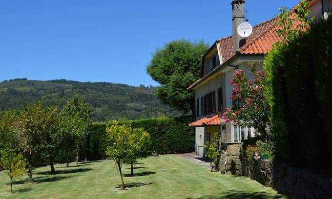 Vila Verde Casa | Gran casa de piedra en una propiedad arbolada con piscina.