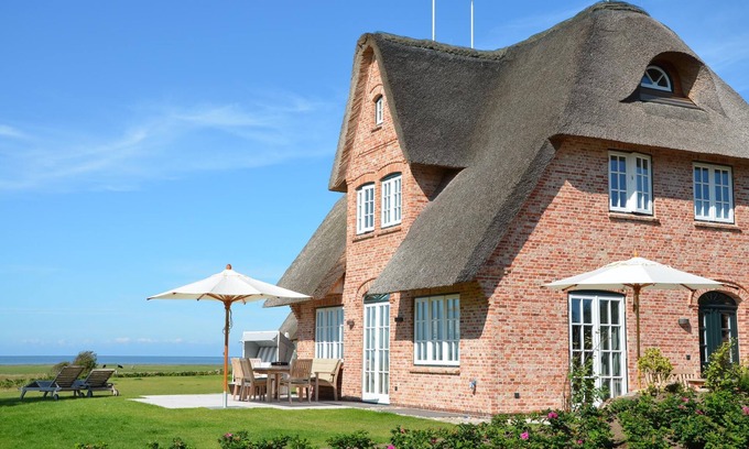 Großmorsum Casa | New building under thatch with an unobstructed view of the water.