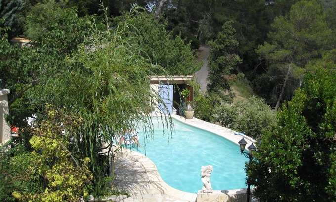 Carces Casa | Casa de campo provenzal en piedras naturales en una colina boscosa con piscina.