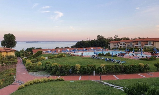 Manerba del Garda Apartamento | Impresionante vista al lago de tres habitaciones en una residencia con tres piscinas y 36,000 m2 de vegetación