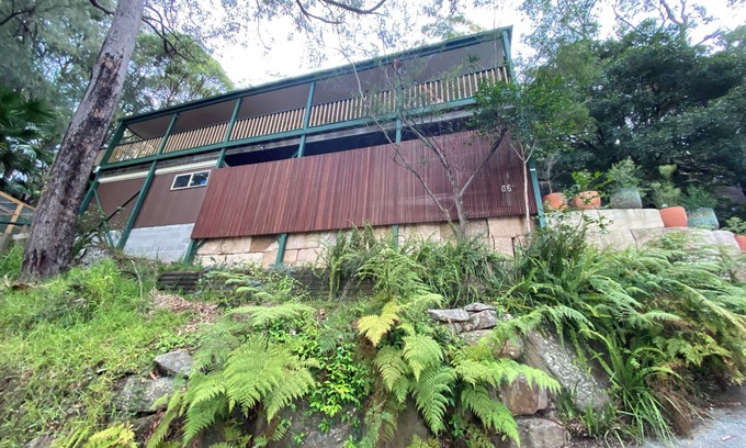 Patonga Casa | Treetops retreat - pole house set against a sandstone rock face in the tree tops