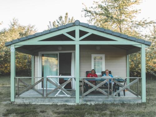 Beynat Chalet De Esquí | Wooden chalet with covered terrace on the edge of a lake