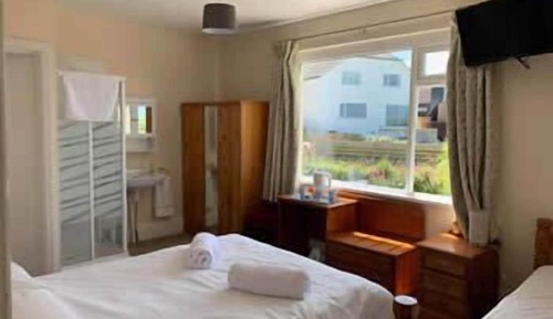Habitación con 2 camas individuales, baño privado, vistas parciales al mar