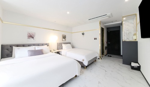 Habitación Deluxe con 2 camas individuales, varias camas, vistas parciales al mar, frente al mar