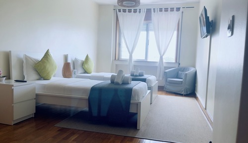 Habitación con 2 camas individuales, baño compartido, vistas a la ciudad