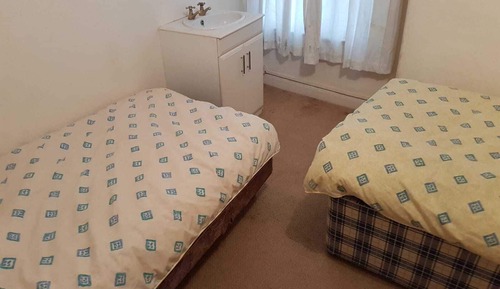 Habitación básica con 2 camas individuales, baño compartido