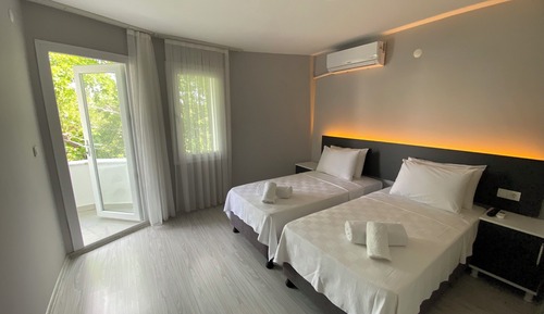 Habitación básica con 2 camas individuales, balcón, vistas al jardín